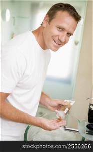 Man in bathroom with hair gel smiling