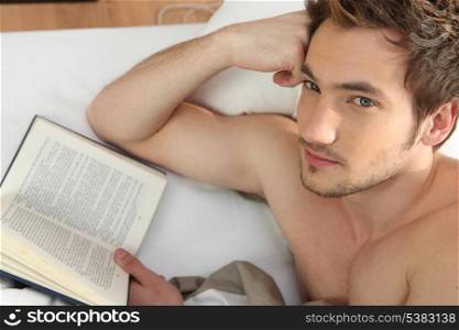 Man in bed reading book
