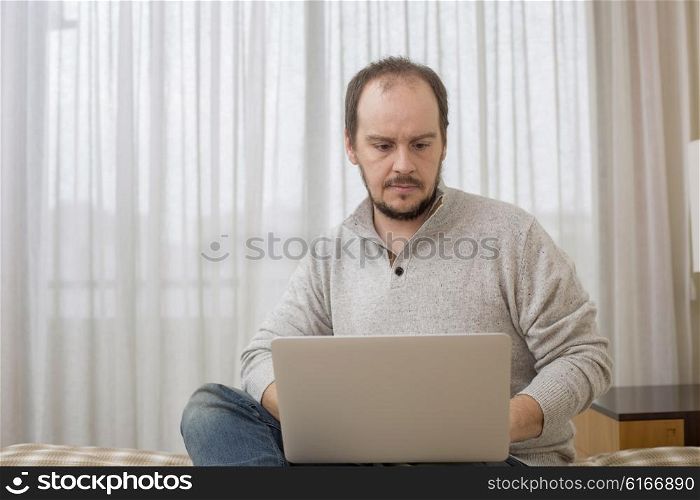 man in bed working with a laptop