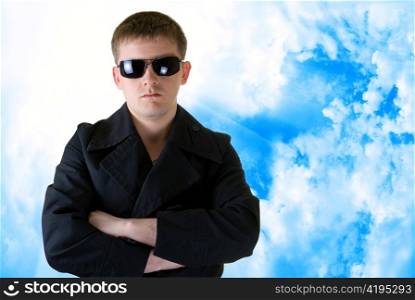 Man in black clothes on blue sky background
