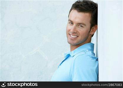 Man in Blue Leaning Against Wall
