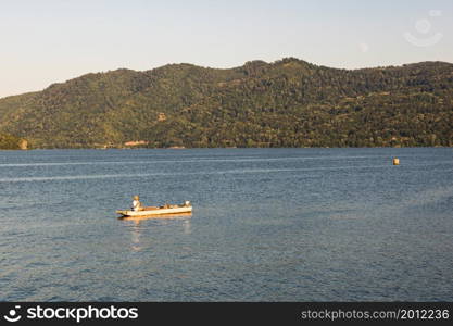 Man in boat relaxing and fishing on Danube river on a sunny day in Orsova, Romania, 2020.