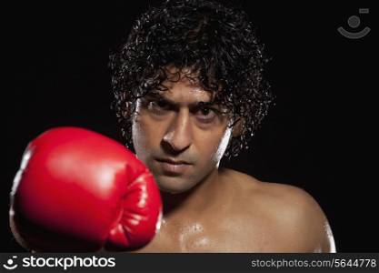 Man in boxing stance over black background