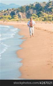 man in bright clothing runs along the beach line