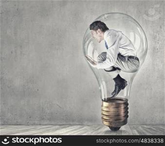 Man in bulb. Screaming businessman trapped inside of light bulb