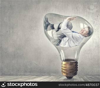 Man in bulb. Screaming businessman trapped inside of light bulb