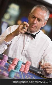 Man in casino playing roulette and smoking cigar (selective focus)
