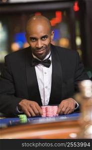 Man in casino playing roulette smiling (selective focus)