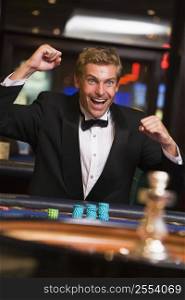 Man in casino winning at roulette and smiling (selective focus)