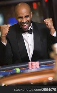 Man in casino winning roulette and smiling (selective focus)