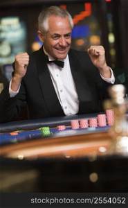 Man in casino winning roulette smiling (selective focus)