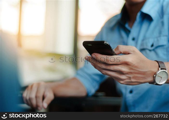 man in casual form using mobile phone at modern office