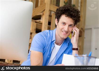 Man in casual wear with his mobile in office