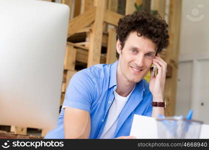 Man in casual wear with his mobile in office