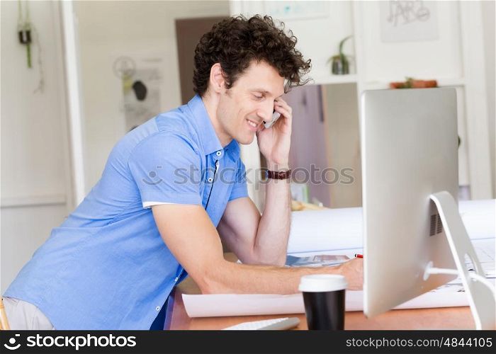Man in casual wear with his mobile in office