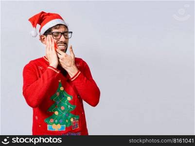 Man in christmas sweater with toothache, Young man in christmas hat with toothache isolated, Man in christmas hat in pain touching his tooth. Christmas toothache concept