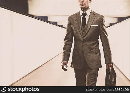 Man in classic suit with briefcase walking through corridor