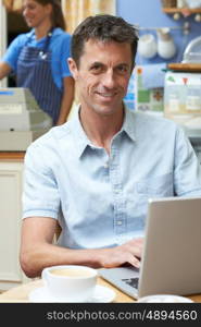 Man In Coffee Shop Using Laptop Computer