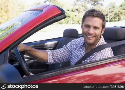 Man in convertible car smiling