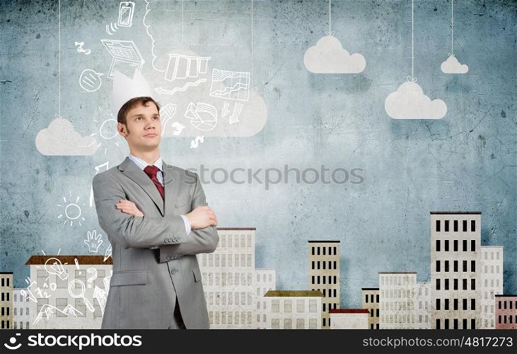 Man in crown. Young handsome businessman wearing white paper crown