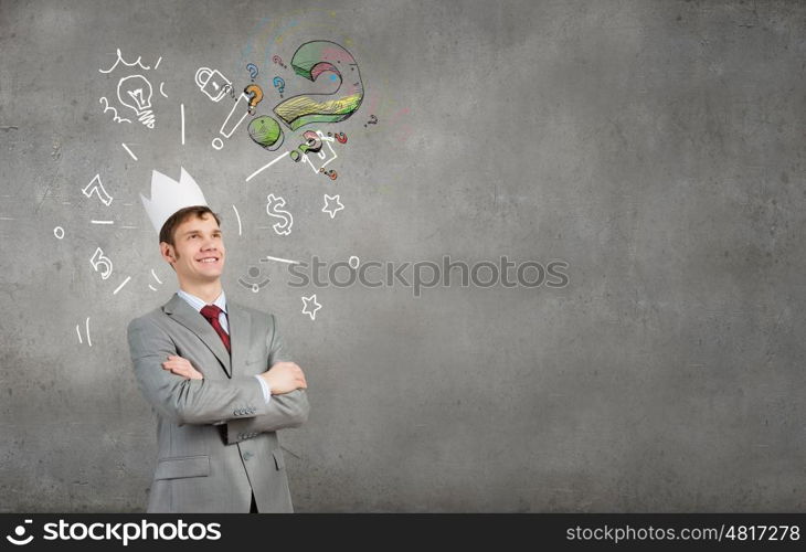 Man in crown. Young handsome businessman wearing white paper crown