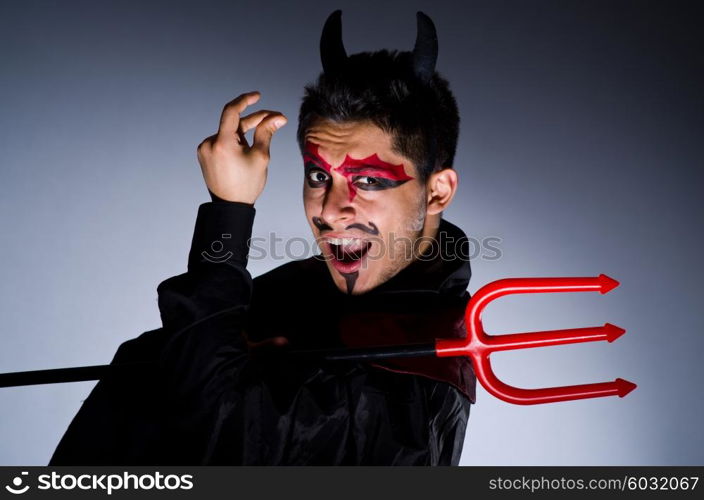 Man in devil costume in halloween concept