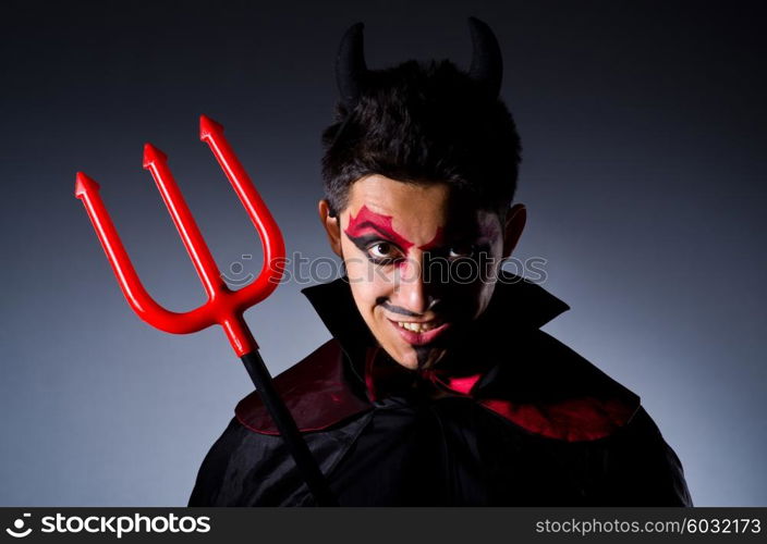 Man in devil costume in halloween concept