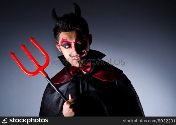 Man in devil costume in halloween concept