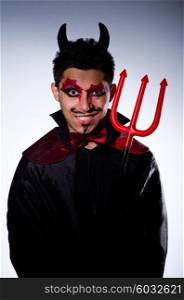 Man in devil costume in halloween concept