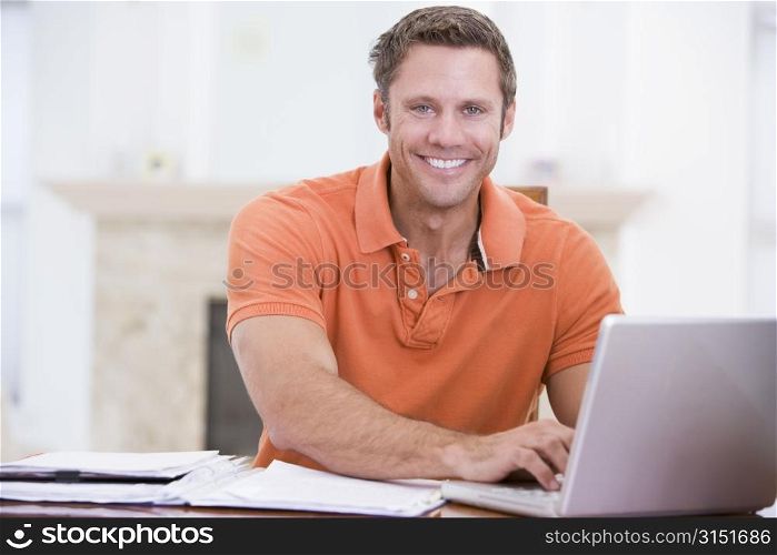 Man in dining room with laptop smiling