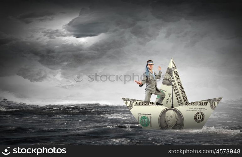 Man in dollar boat. Businessman escapes from crisis on paper boat made of dollar banknote