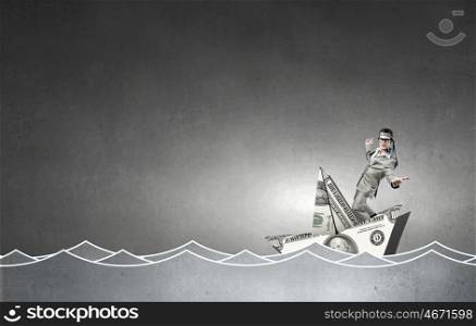 Man in dollar boat. Businessman escapes from crisis on paper boat made of dollar banknote