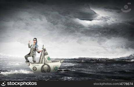 Man in dollar boat. Businessman escapes from crisis on paper boat made of dollar banknote