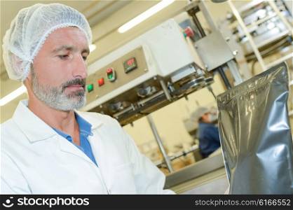 Man in factory with sealed bag