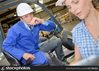 Man in forklift taking instructions from lady