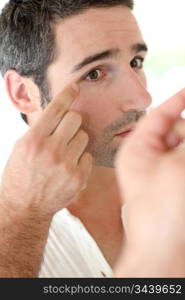 Man in front of mirrror looking at his wrinkles