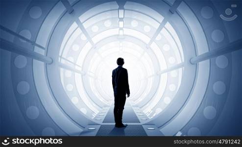 Man in futuristic interior. Businessman standing in virtual designed tunnel room