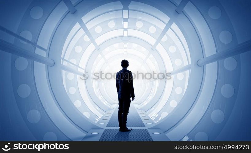 Man in futuristic interior. Businessman standing in virtual designed tunnel room
