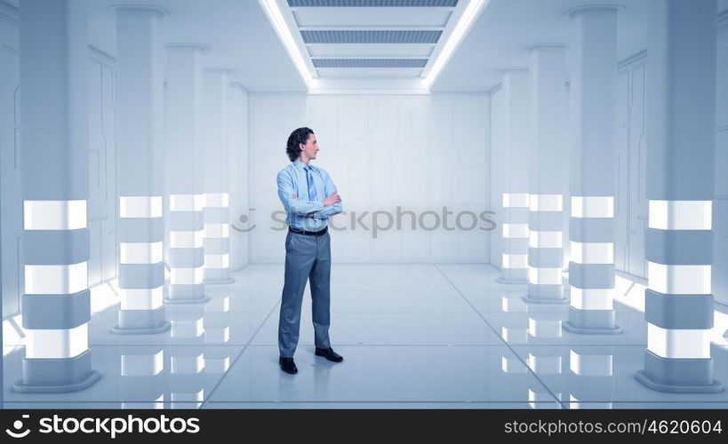 Man in futuristic interior. Confident businessman with arms crossed on chest in virtual tunnel room