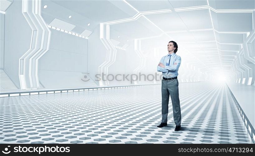 Man in futuristic interior. Confident businessman with arms crossed on chest in virtual tunnel room