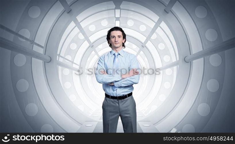 Man in futuristic interior. Confident businessman with arms crossed on chest in virtual tunnel room
