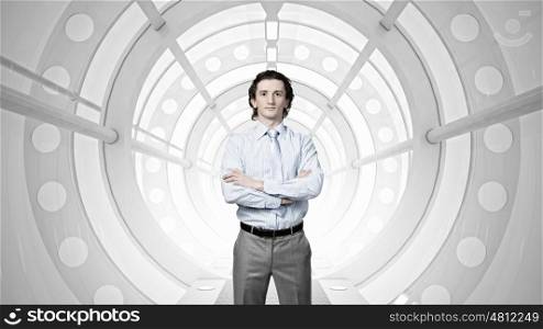 Man in futuristic interior mixed media. Young confident businessman with arms crossed on chest in virtual room