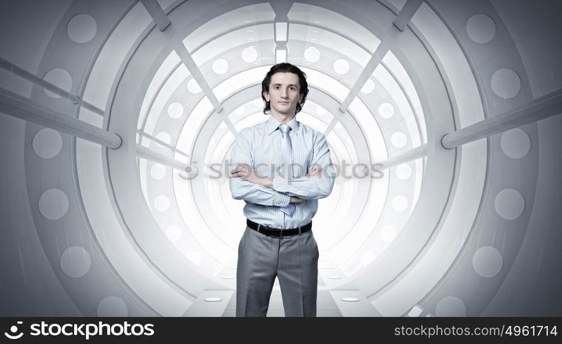 Man in futuristic interior mixed media. Young confident businessman with arms crossed on chest in virtual room