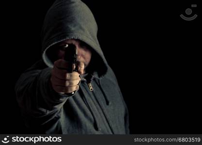 Man in green hoodie points gun