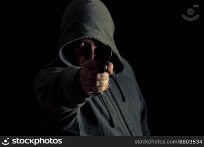 Man in green hoodie points gun