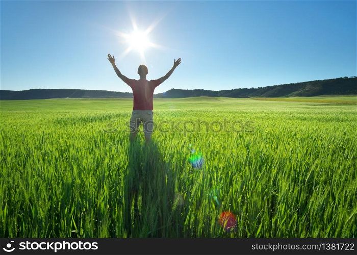 Man in green meadow and sunshine. Conceptual active and agricultural scene.