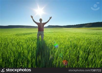 Man in green meadow and sunshine. Conceptual active and agricultural scene.