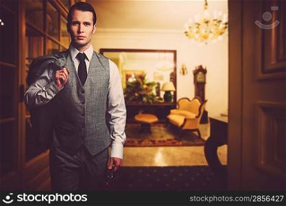 Man in grey waistcoat with briefcase in luxury home interior