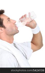 Man in gym clothes drinking a bottle of water