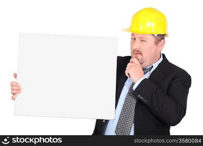 Man in hard hat holding blank message board